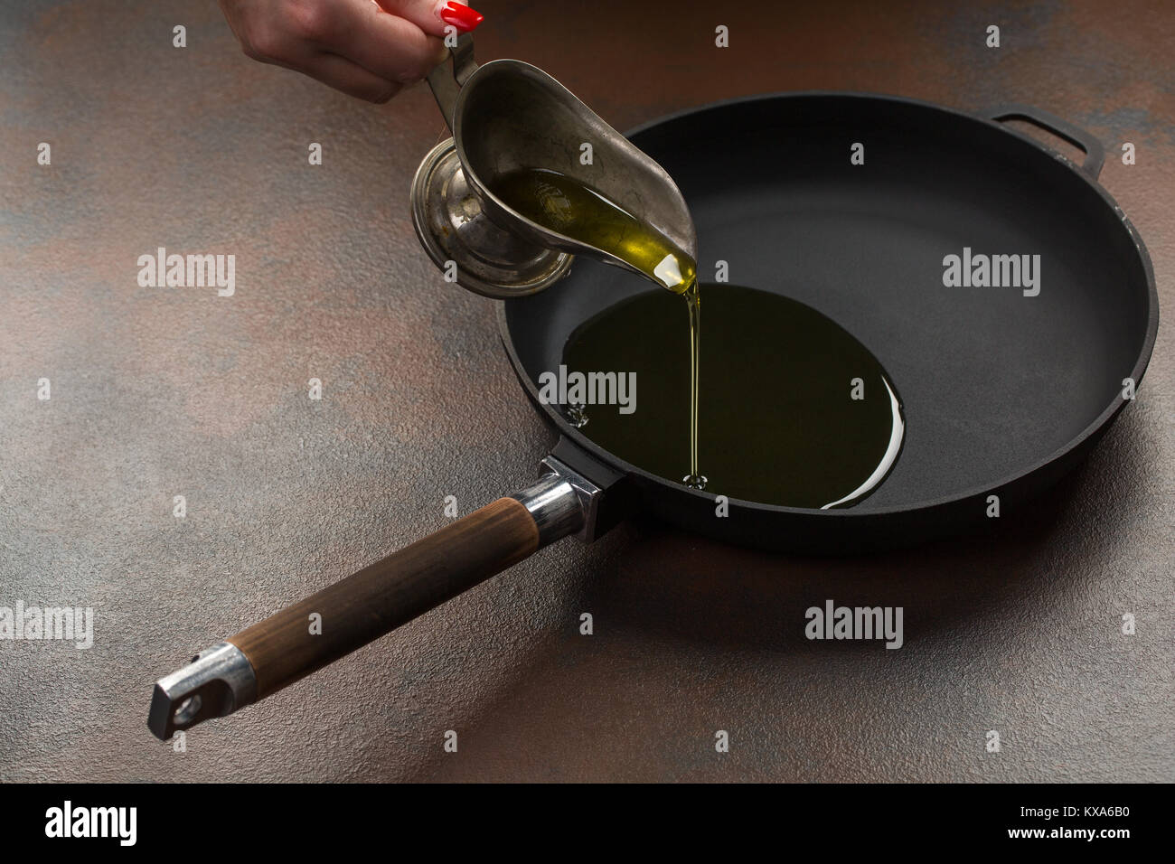 Olive oil poured into the frying pan from the sausage over dark