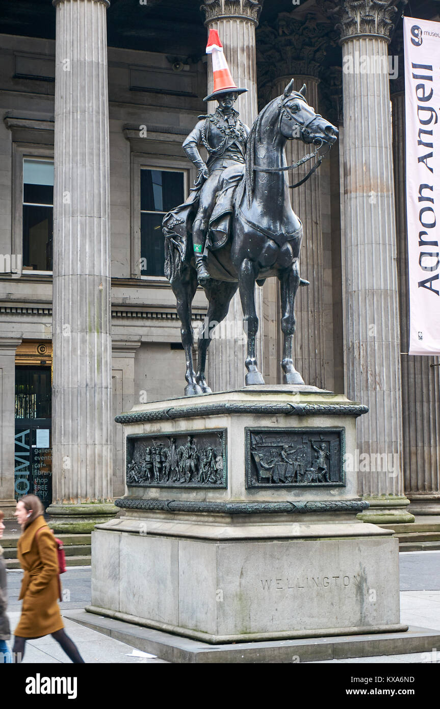 Famous equestrian statue of Duke of Wellington  with a road cone on his head, and a Santa hat during the festive period, in front of the GoMA. Stock Photo