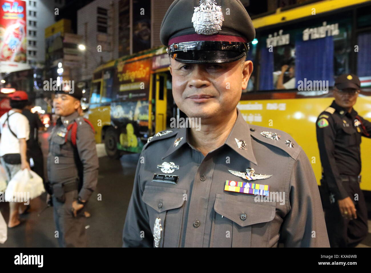 A Thai police officer patrols street food vendors in Chinatown, Bangkok, Thailand Stock Photo