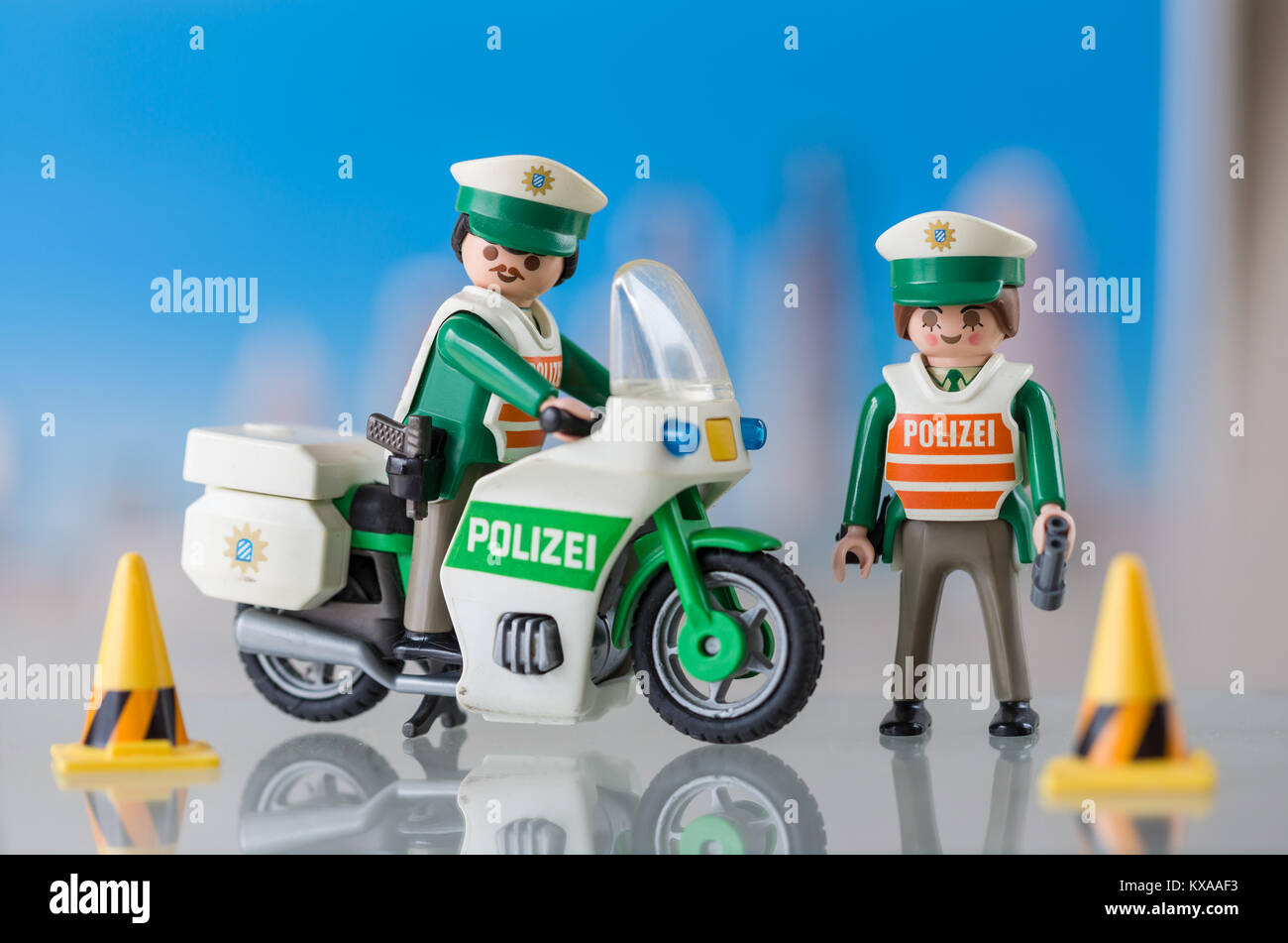 A Playmobil german policeman on a motorbike and policewoman standing.  Playmobil are famous construction toys manufactured by the Brandstaetter  Group Stock Photo - Alamy