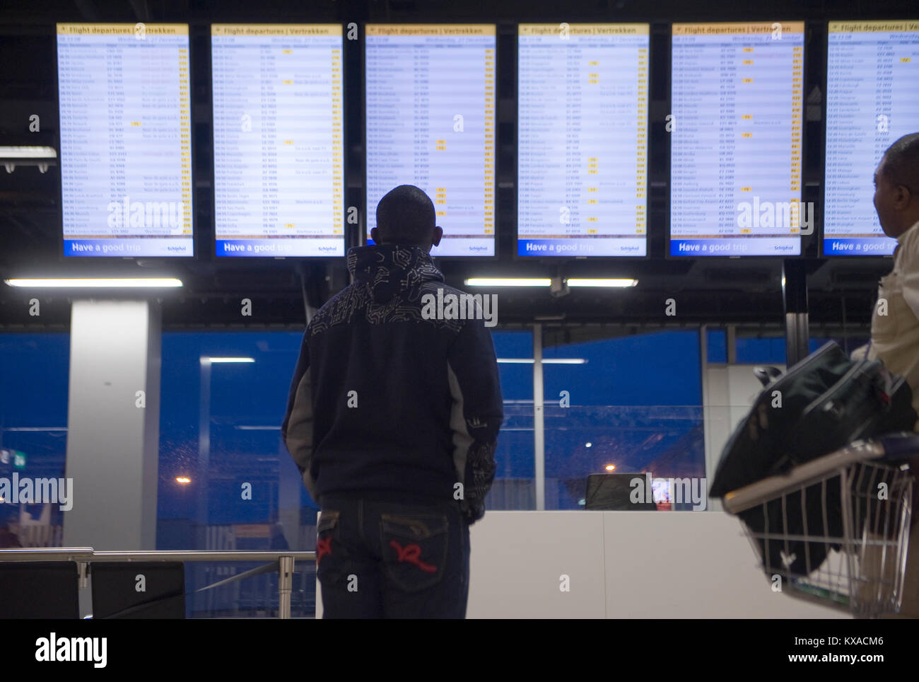AMSTERDAM, NETHERLANDS - DEC 27, 2017: A man is looking at the information screens to check his flight on Schiphol airport near Amsterdam Stock Photo