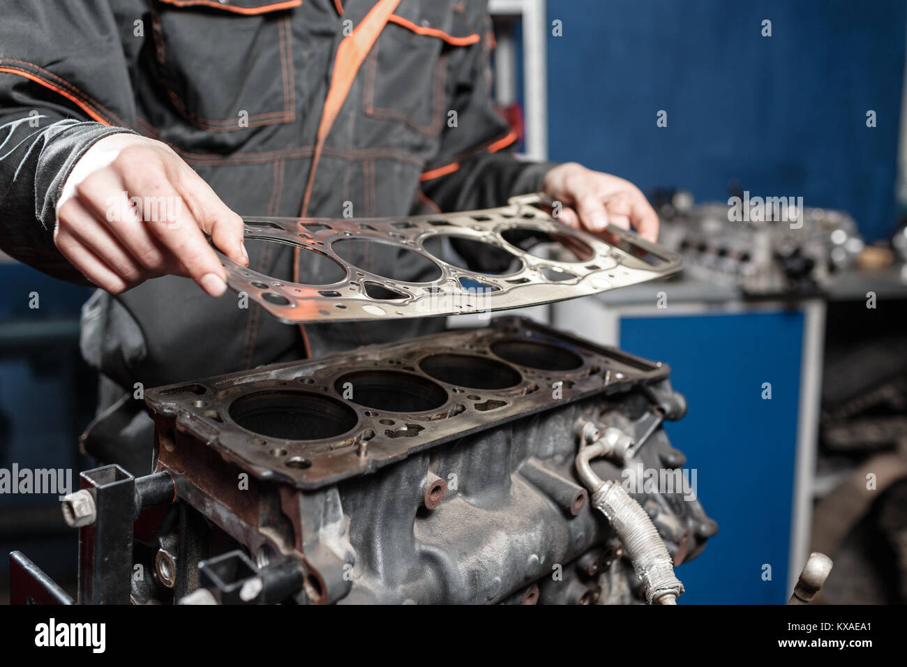 Sealing gasket in hand. The mechanic disassemble block engine vehicle