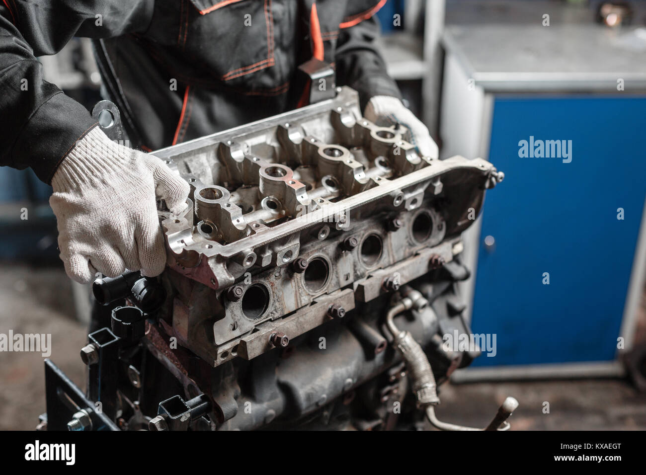 The mechanic disassemble block engine vehicle. Engine on a repair stand