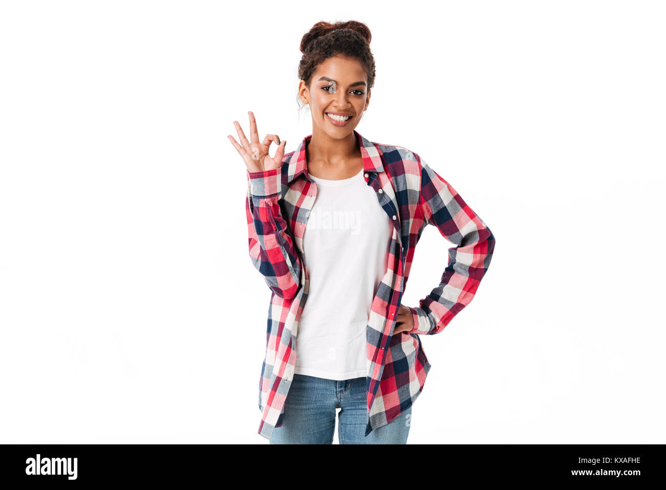 Portrait of a smiling young african woman showing ok gesture isolated ...