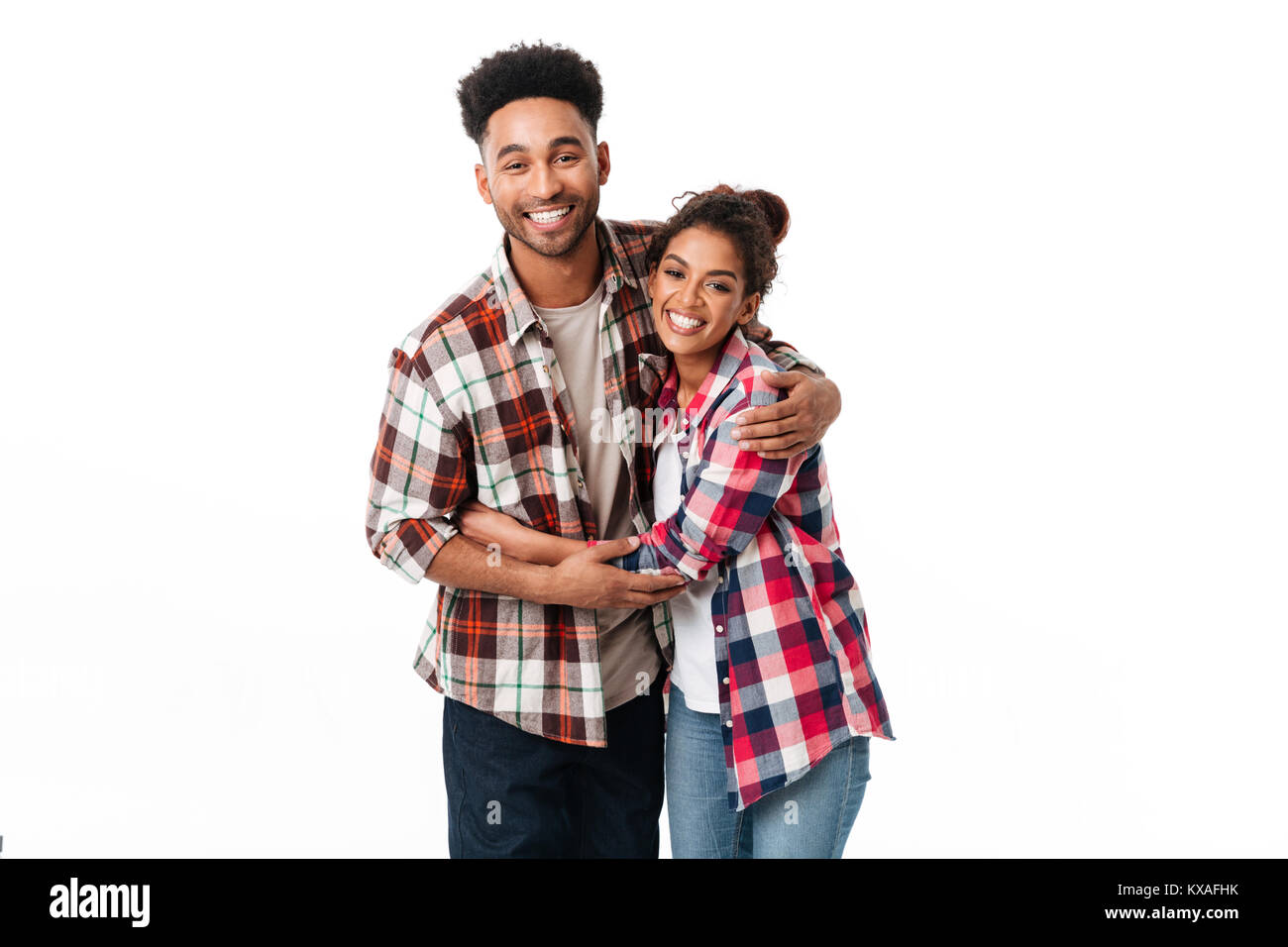 Portrait of a happy young african couple hugging while standing ...