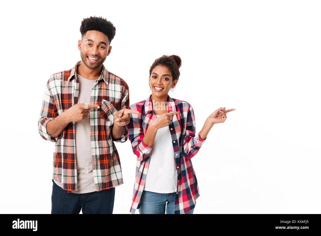 Portrait of a happy young african couple standing together and pointing ...