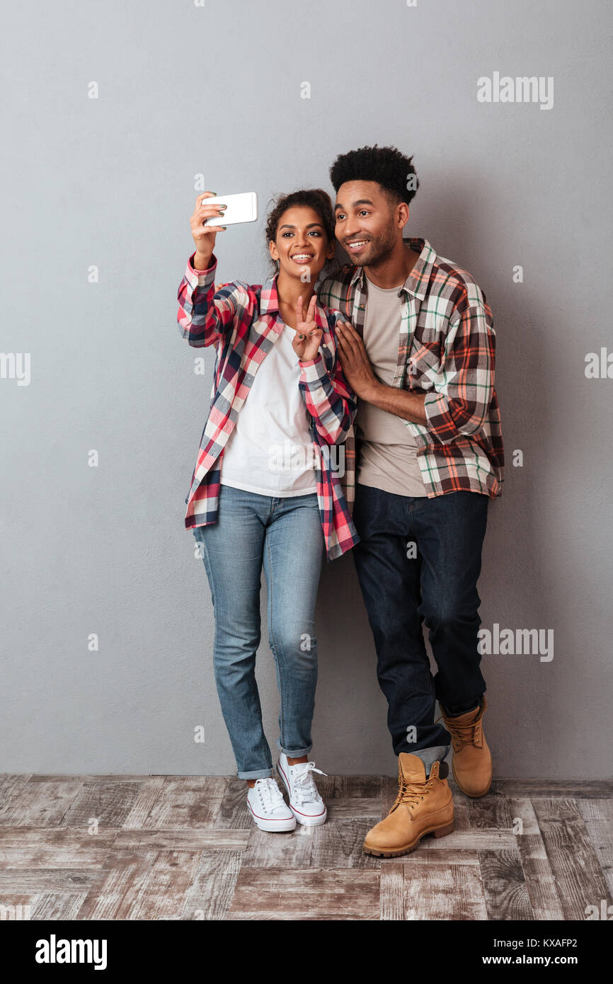 Full length portrait of a happy young african couple showing peace ...