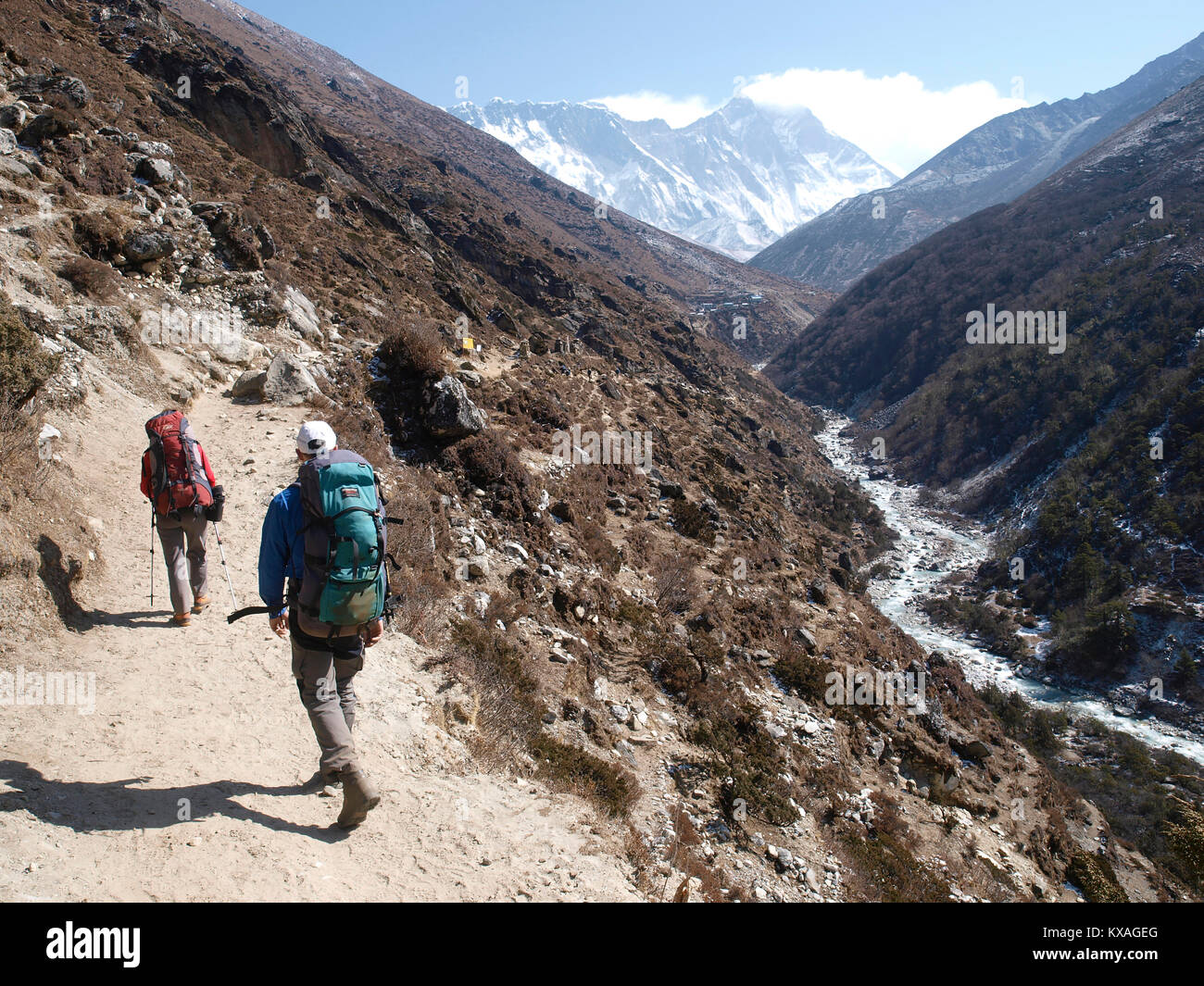 Two hikers on trail of Khumbu valley, just after Namche Bazar, with summit of Mount Everest in background, Nepal Stock Photo