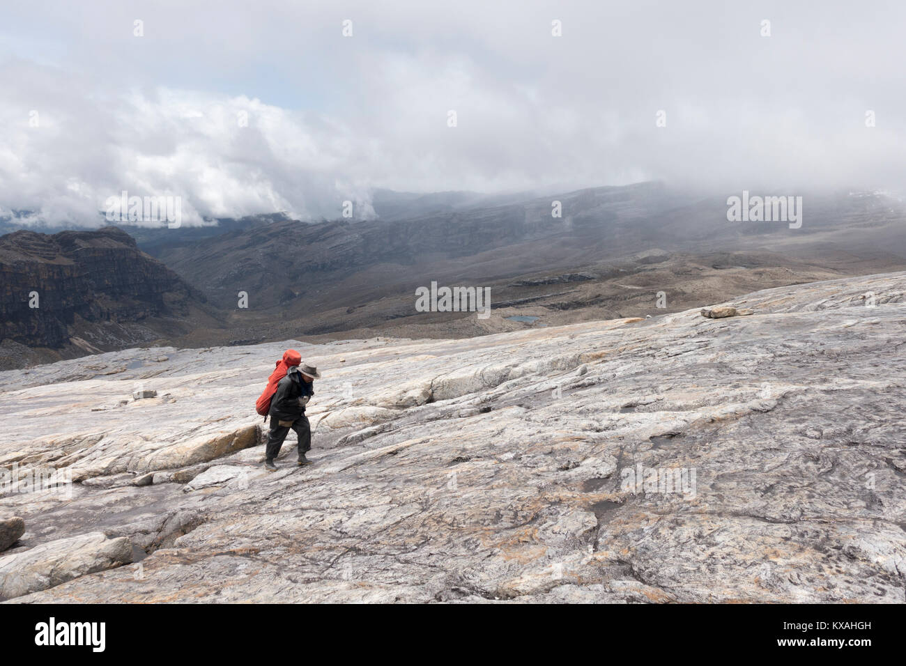 Porter carrying weight and hiking up at Sierra Nevada del Cocuy, Boyaca, Colombia Stock Photo