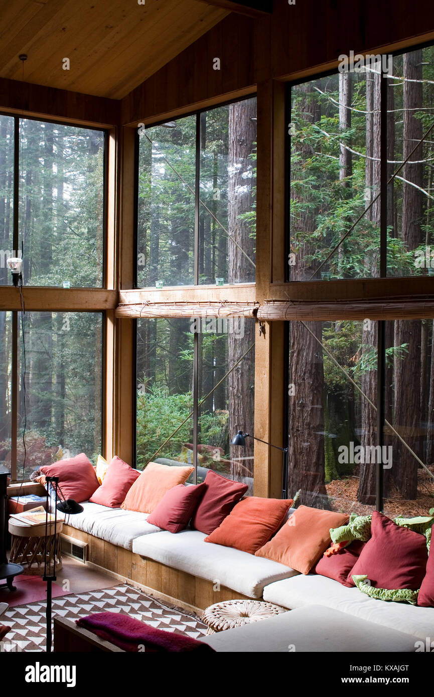Modern home interior with view of forest behind window, Sea Ranch community, Mendocino, California, USA Stock Photo