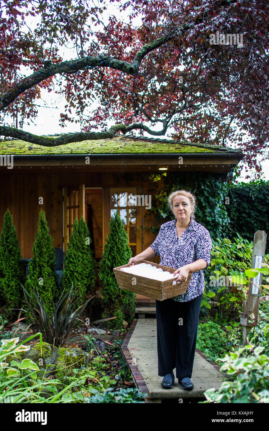 Woman holding towels outside spa building, Galiano Islands, British Columbia, Canada Stock Photo