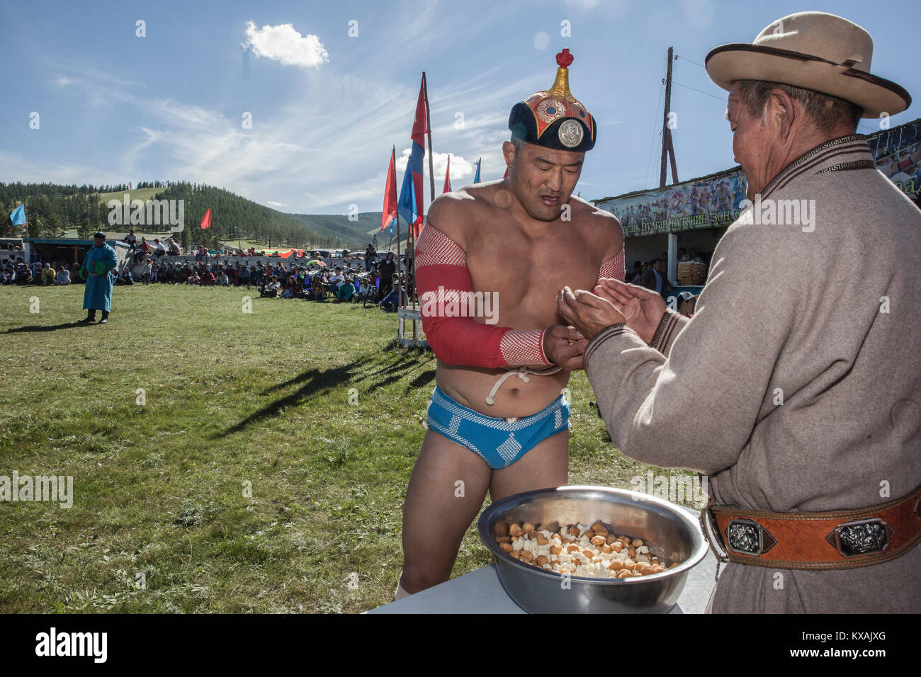 A Mongol wrestler, full of pride, grabbing a handful of the cheese which he will toss into the sky and out to the crowd of his admirers. Annual Naadam Festival in Tsetserleg, Arkhangai Province, Mongolia Stock Photo