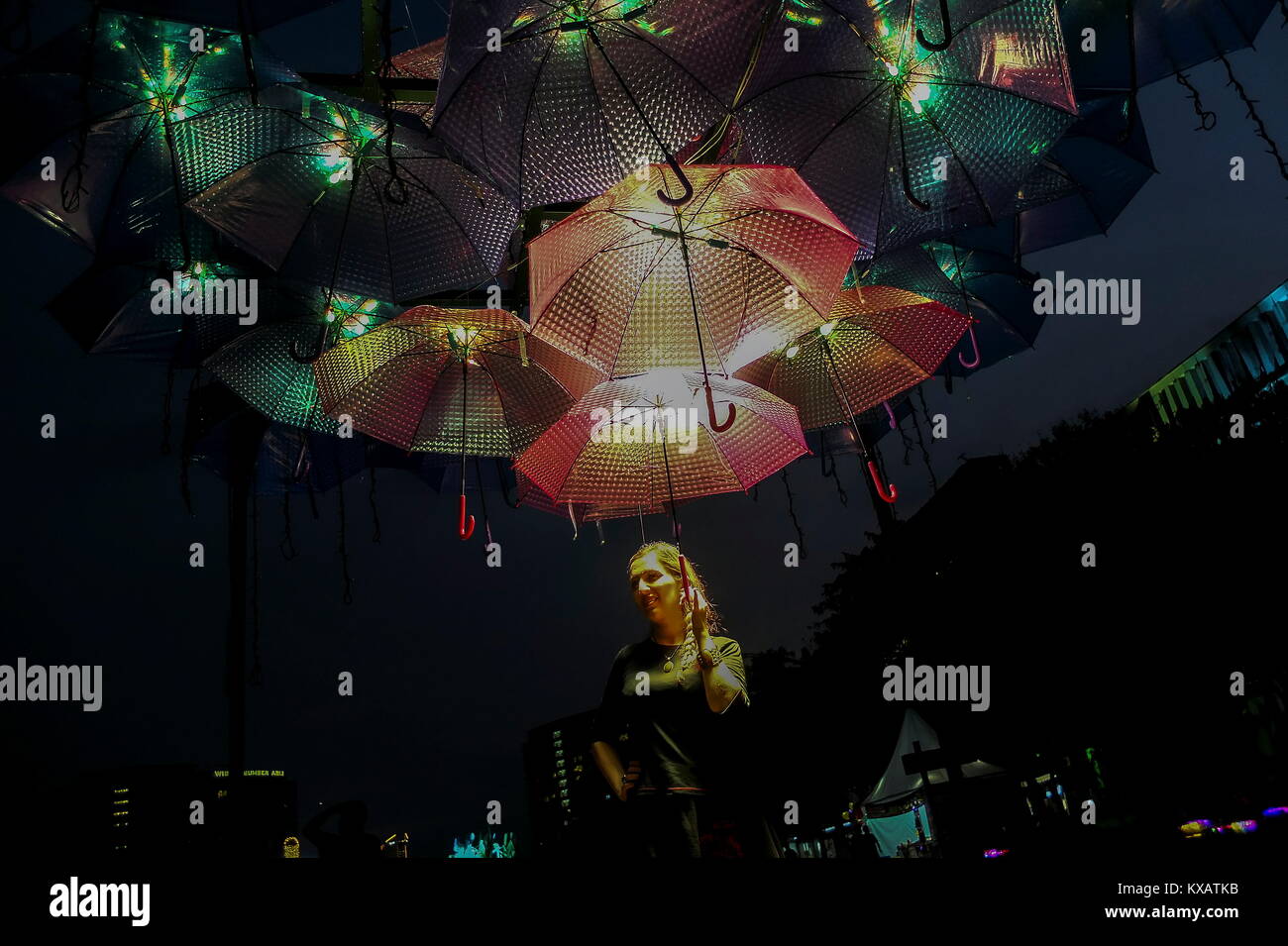 KUALA LUMPUR, MALAYSIA - DECEMBER 28: A women is seen stand under the light umbrella during the Putrajaya Lighting Festival on December 28, 2017 in Putrajaya, Malaysia. The four-night festival featured a light art communities and university students in Malaysia showcasing their creativity of light-themed events, including Luminous lighting effect show, decorative arch and light structure exhibits, car light show, night fun ride, wayang kulit performance (shadow puppetry), and a light garden . Credit: Samsul Said/AFLO/Alamy Live News Stock Photo