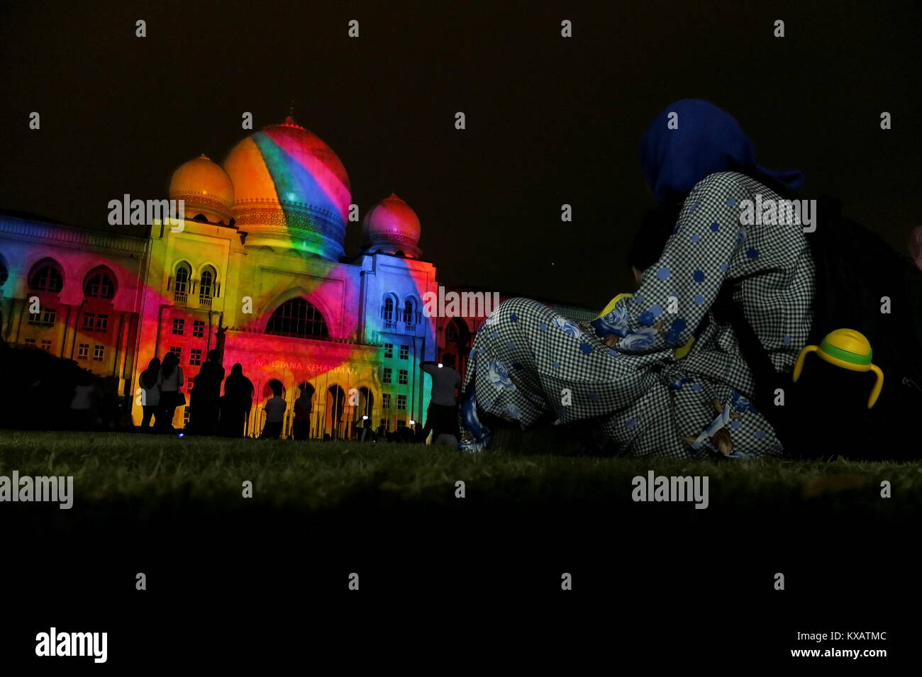 KUALA LUMPUR, MALAYSIA - DECEMBER 28: A women watch a Palace of Justice building is cover by Projection Mapping during the Putrajaya Lighting Festival on December 28, 2017 in Putrajaya, Malaysia. The four-night festival featured a light art communities and university students in Malaysia showcasing their creativity of light-themed events, including Luminous lighting effect show, decorative arch and light structure exhibits, car light show, night fun ride, wayang kulit performance (shadow puppetry), and a light garden . Credit: Samsul Said/AFLO/Alamy Live News Stock Photo