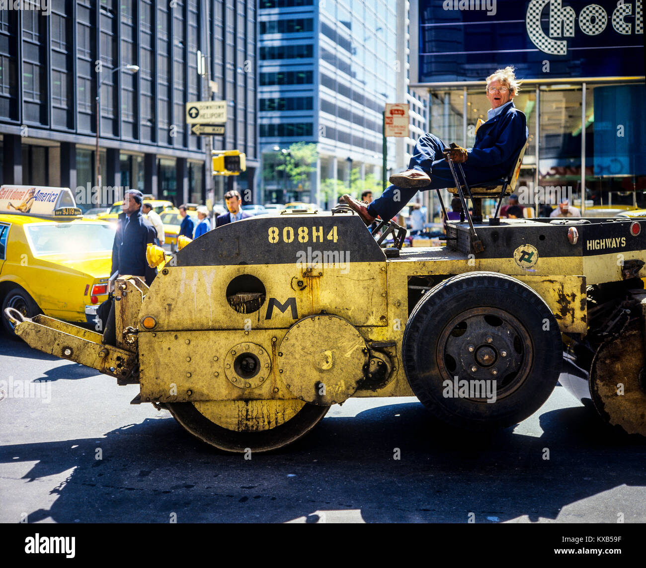 New York 1980s, man driving a yellow road roller, 34th street, Manhattan, New York City, NY, NYC, USA, Stock Photo