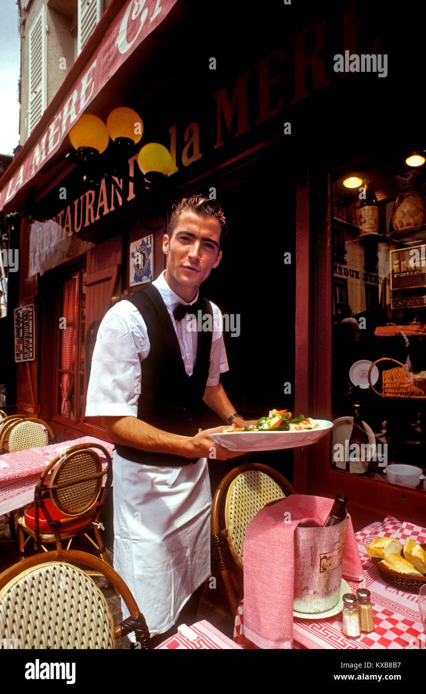 PARIS WAITER MONTMARTRE French waiter serving alfresco lunch with chilled wine on table at