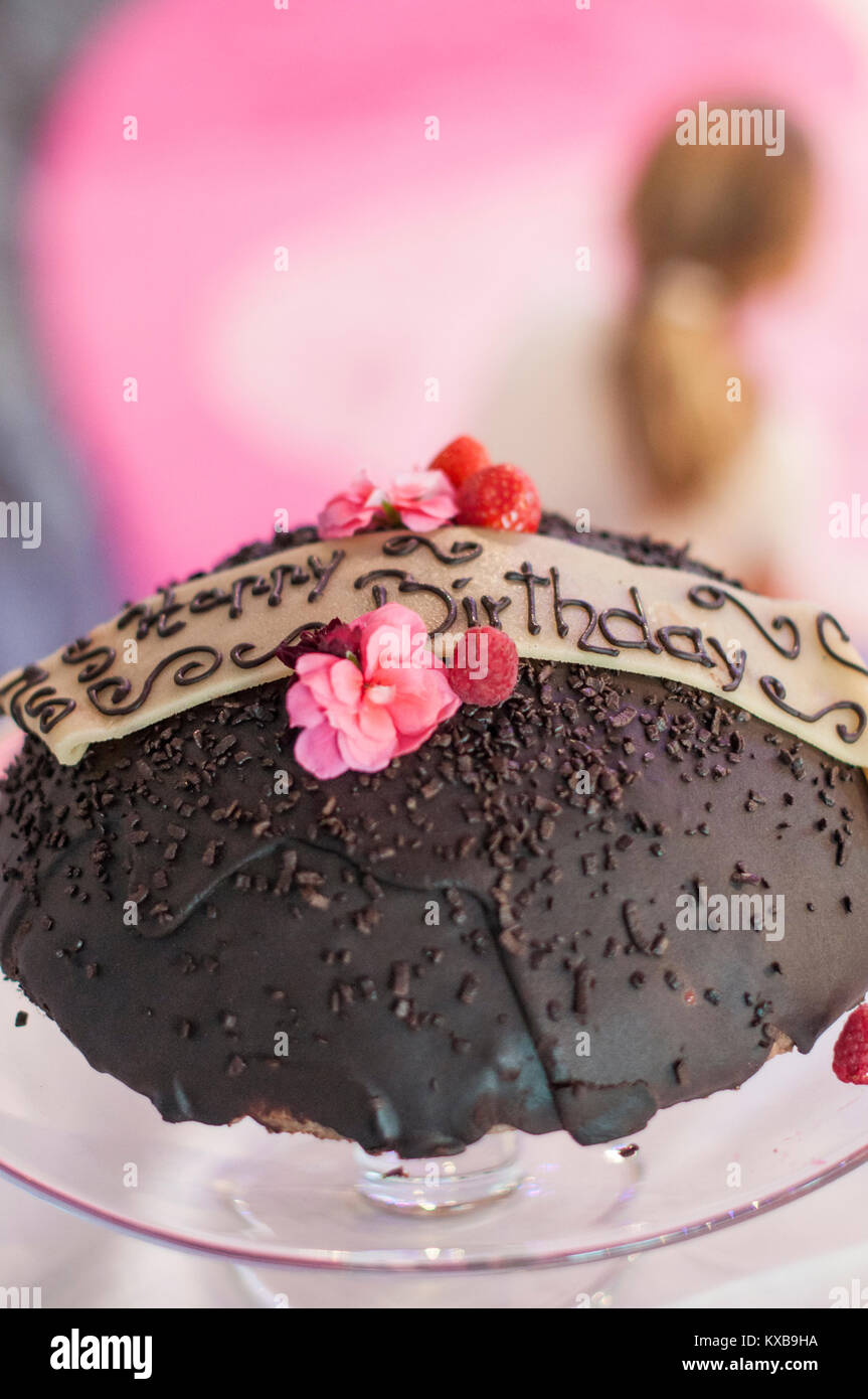 Happy Birthday chocolate cake on glass plate with pink flowers ...