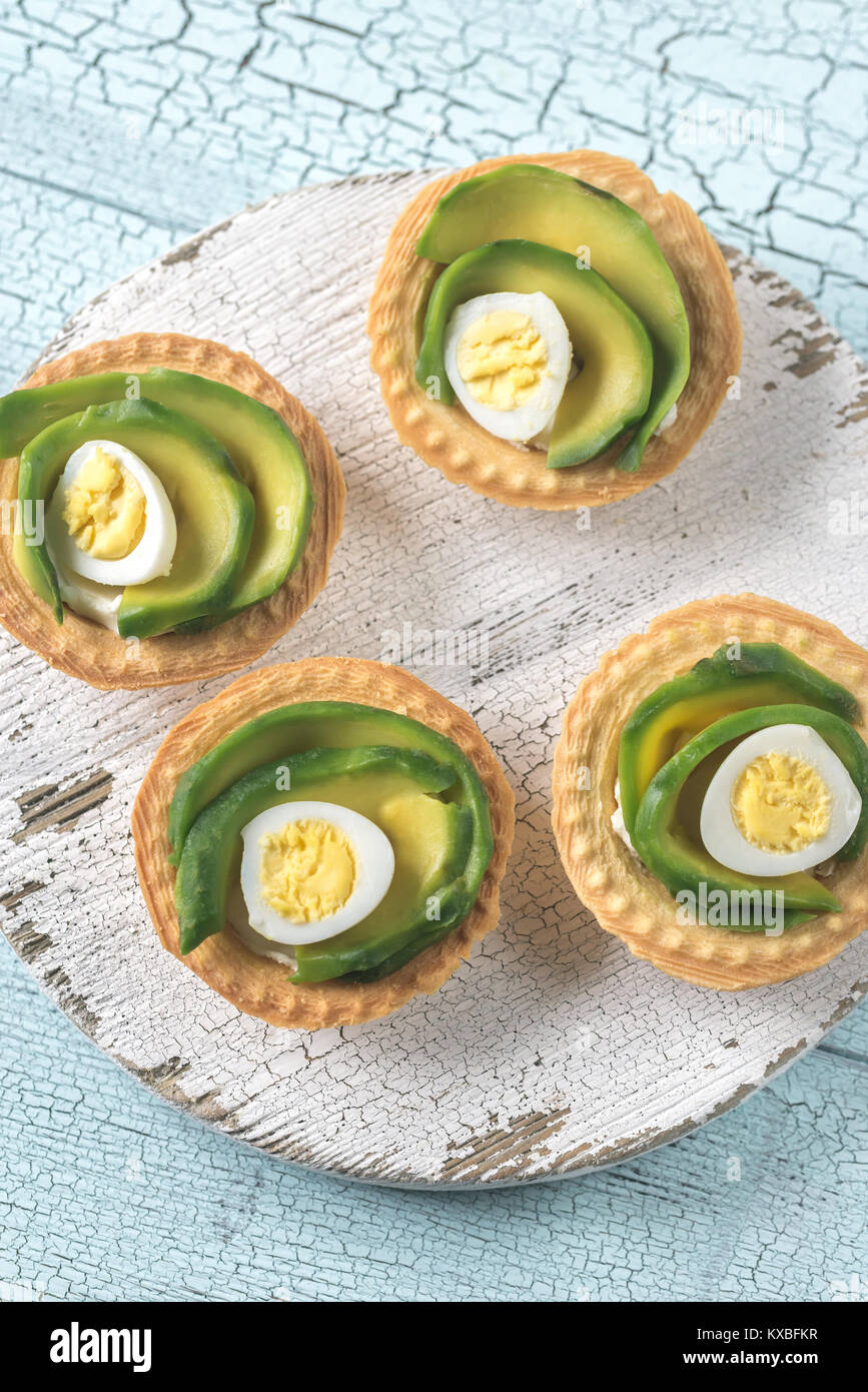 Tartlets with cream cheese, avocado and quail eggs Stock Photo Alamy