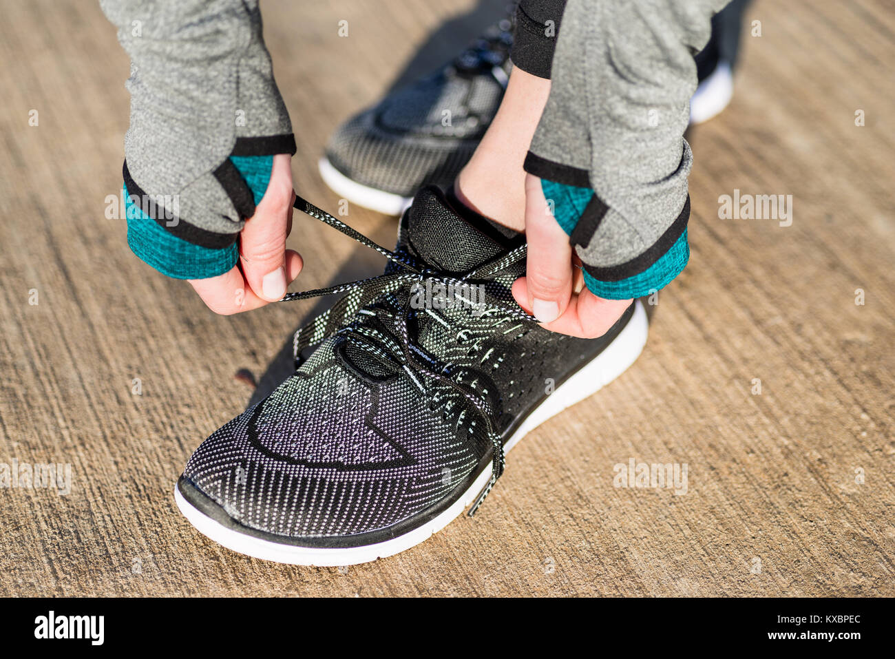 Hands of a woman tying the shoelaces of her comfortable and flex Stock Photo