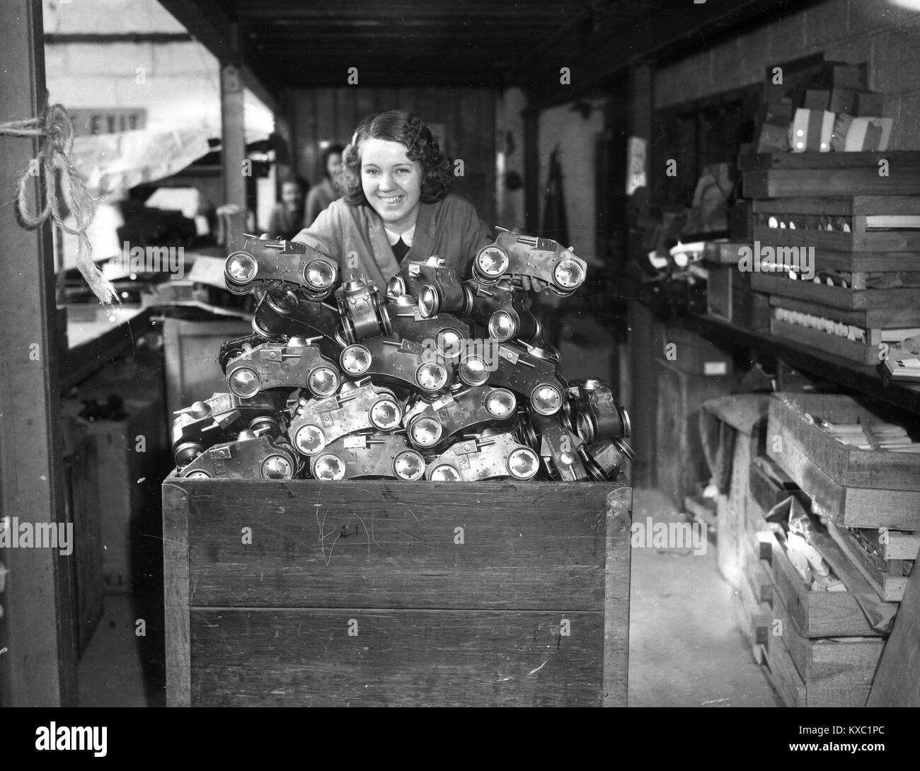 Woman working packing toys at Tri-ang toy 'Tiger' climbing tanks at Lines Brothers Ltd Tri-ang works in Merton, London 1936 Stock Photo