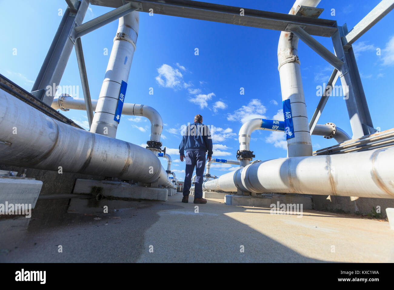 Engineer walking through water treatment plant Stock Photo Alamy