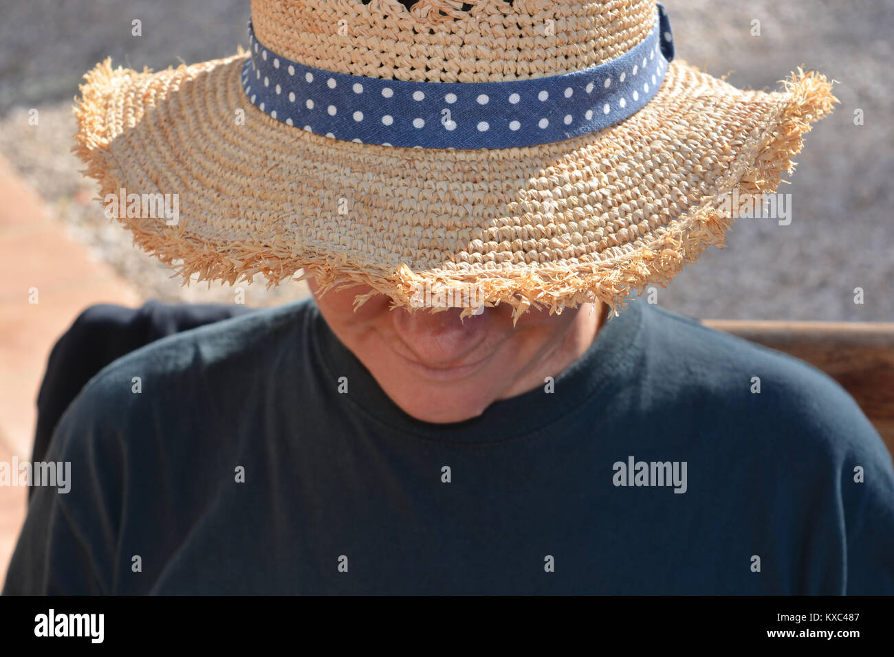 Woman outdoors, wearing a straw hat in hot, sunny weather Stock Photo