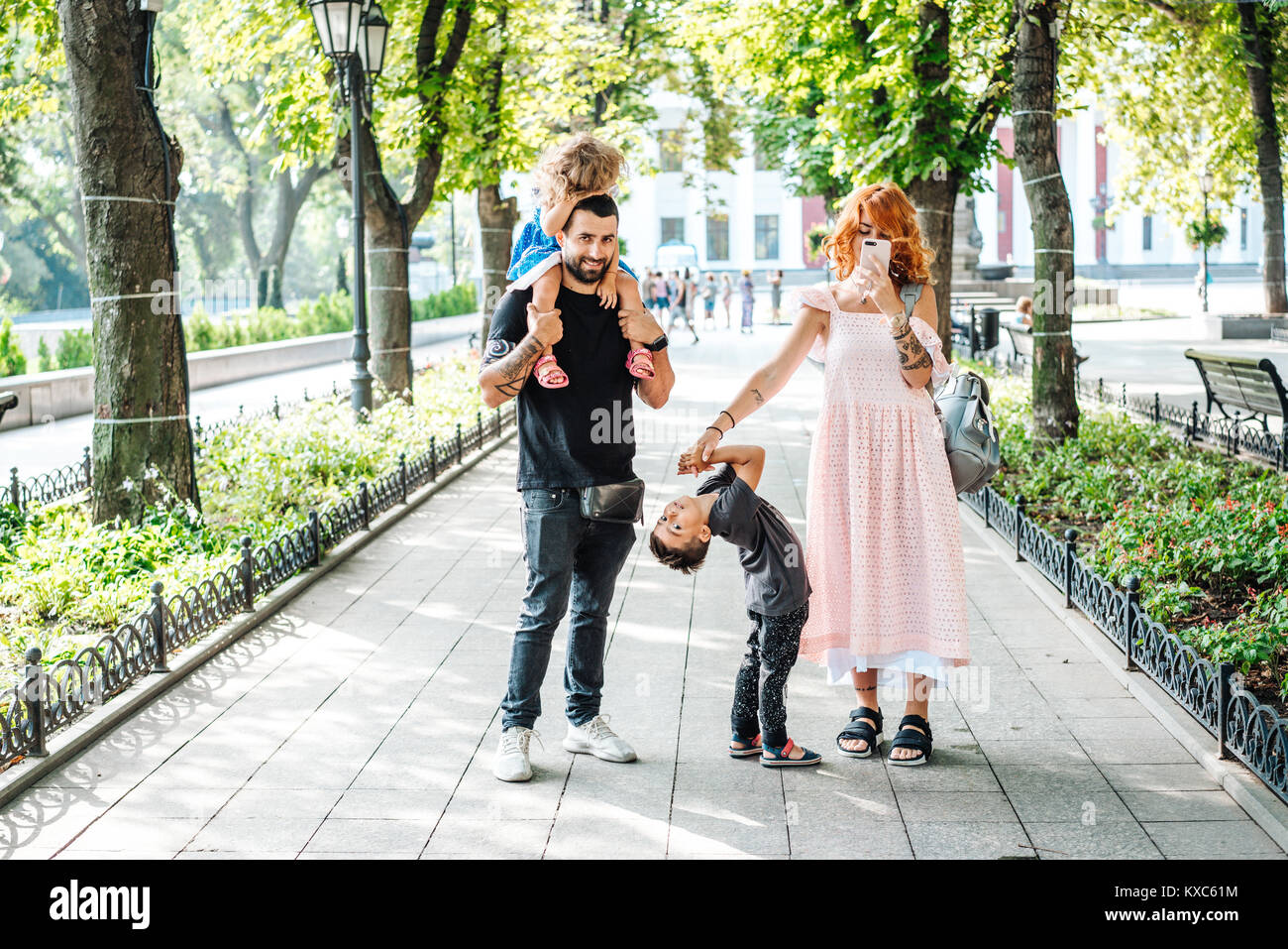 Happy beautiful family walking in the park Stock Photo - Alamy