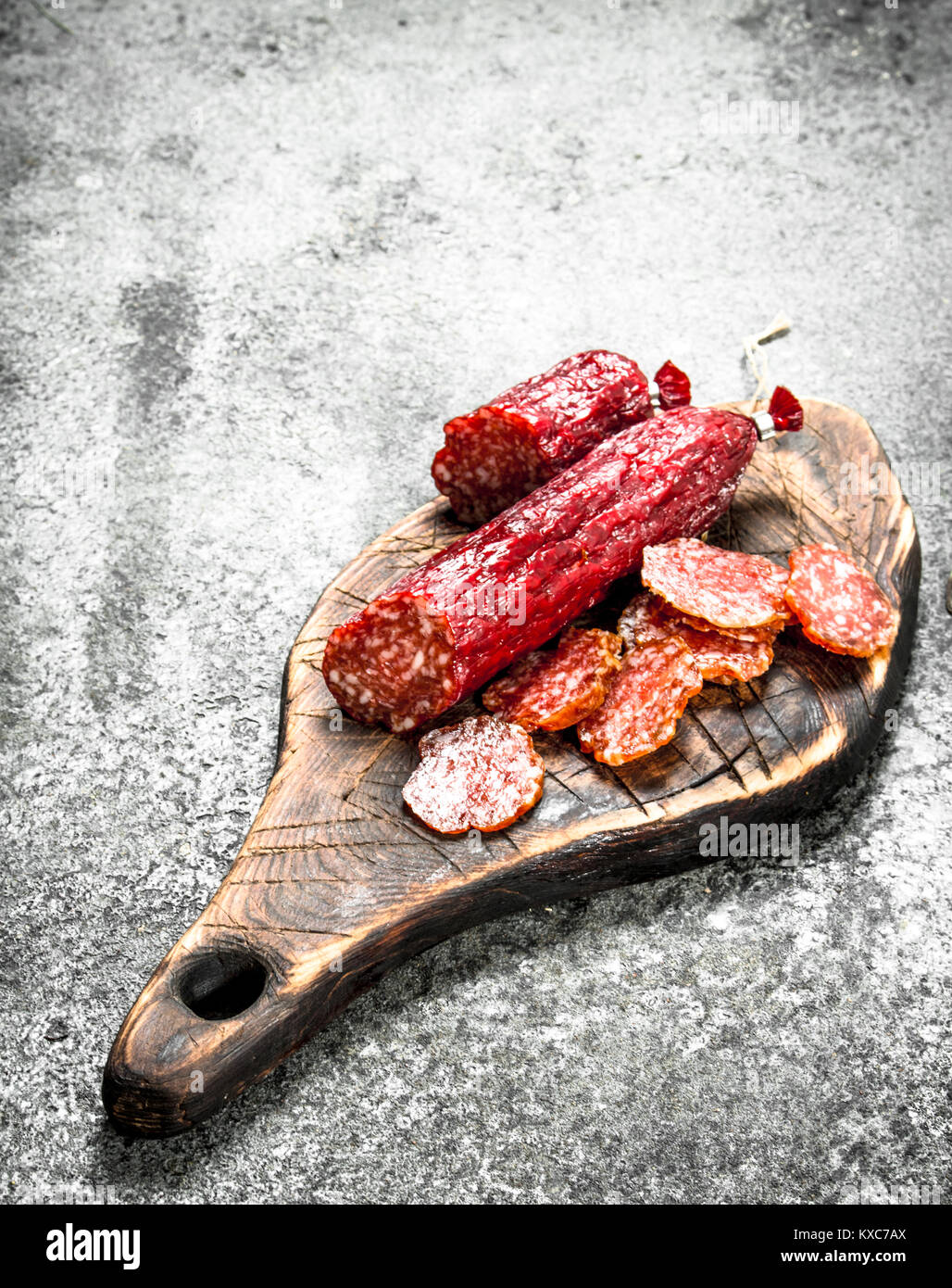 Salami salted on a wooden board. On a rustic background Stock Photo - Alamy