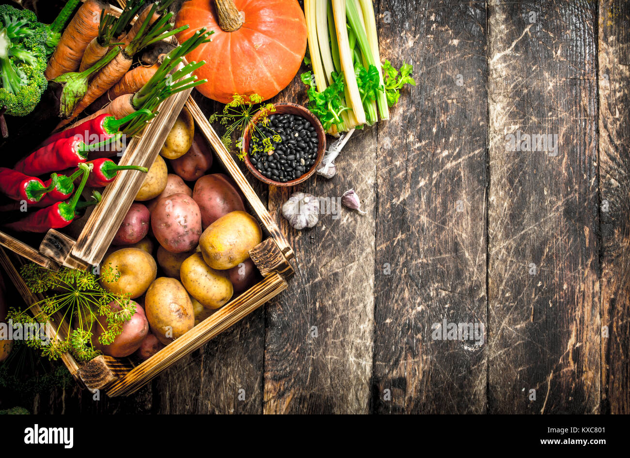 Organic food. Harvest of fresh vegetables in old boxes. On a wooden ...