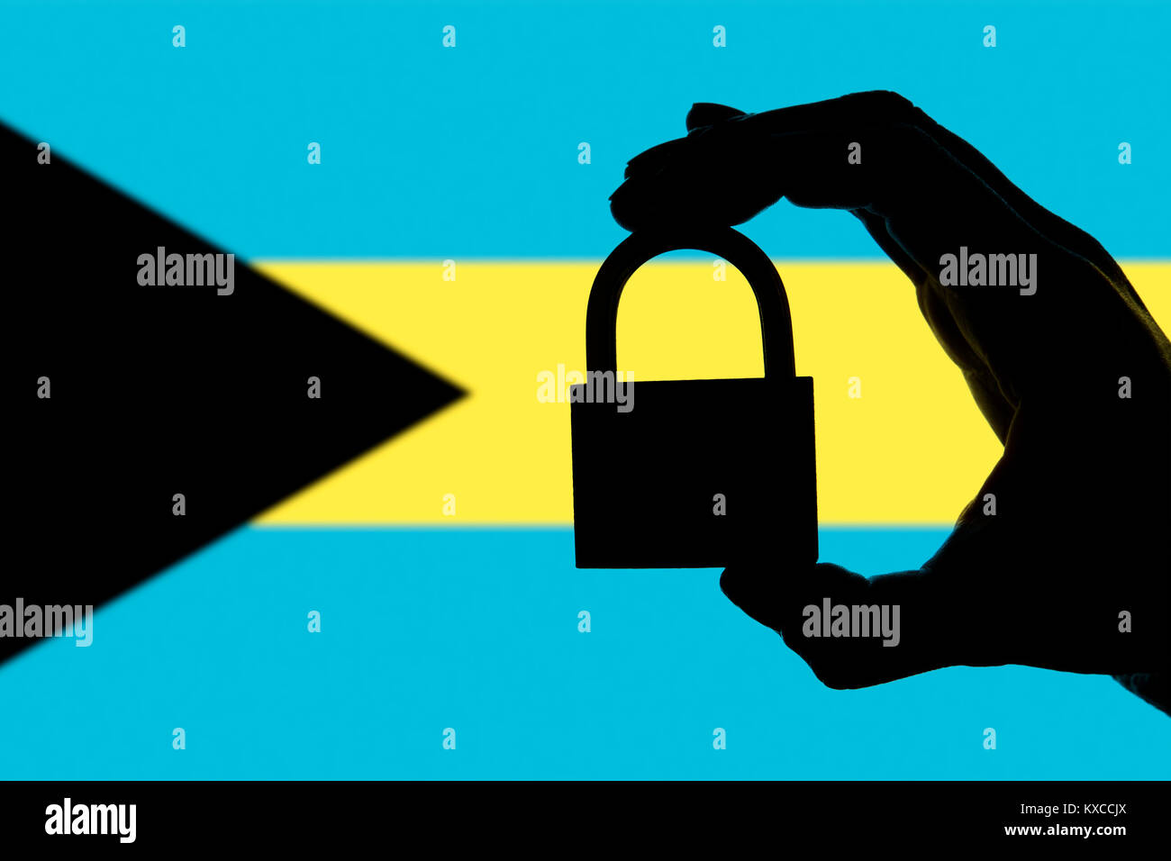 Bahamas security. Silhouette of hand holding a padlock over national
