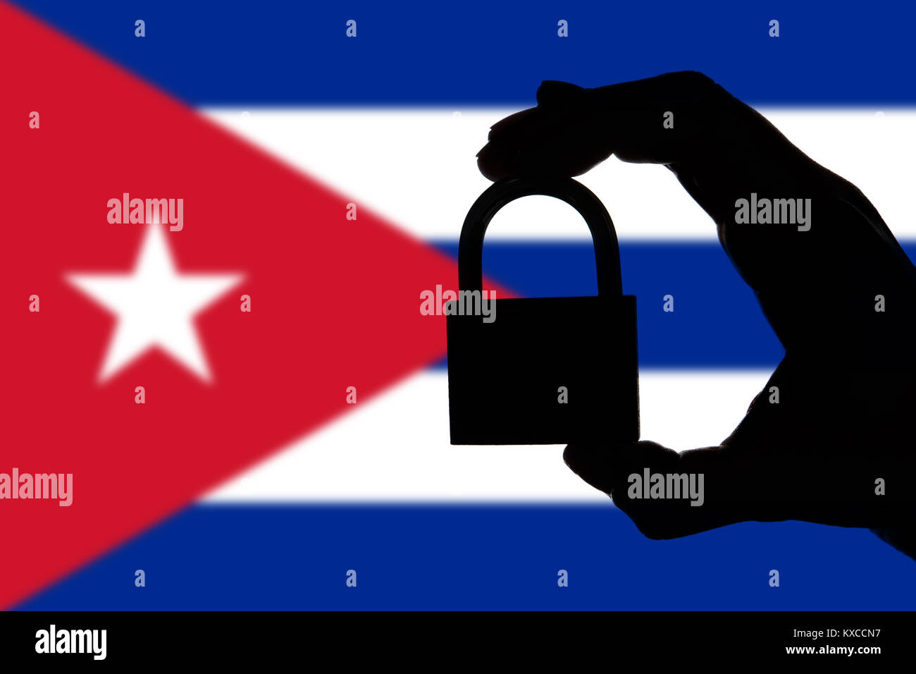 Cuba security. Silhouette of hand holding a padlock over national flag Stock Photo