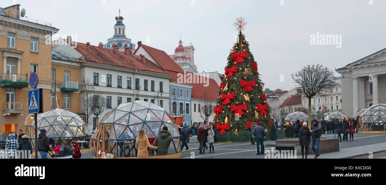 VILNIUS, LITHUANIA - DECEMBER 30, 2017:  Christmas tree in the Town Hall Square is decorated with red bows and light bulbs garlands Stock Photo