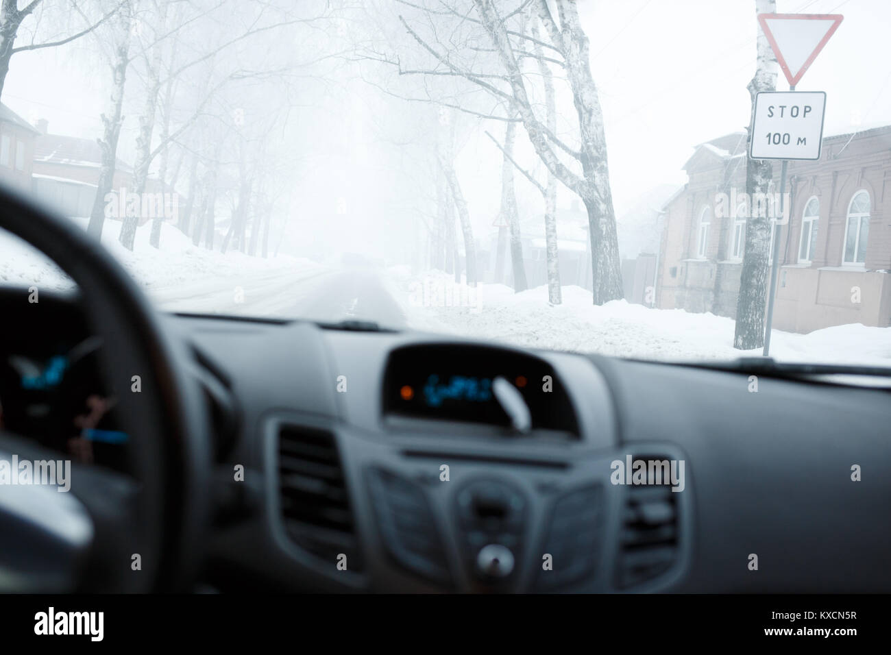 Bad weather driving in winter. Blizzard and fog on the road with low