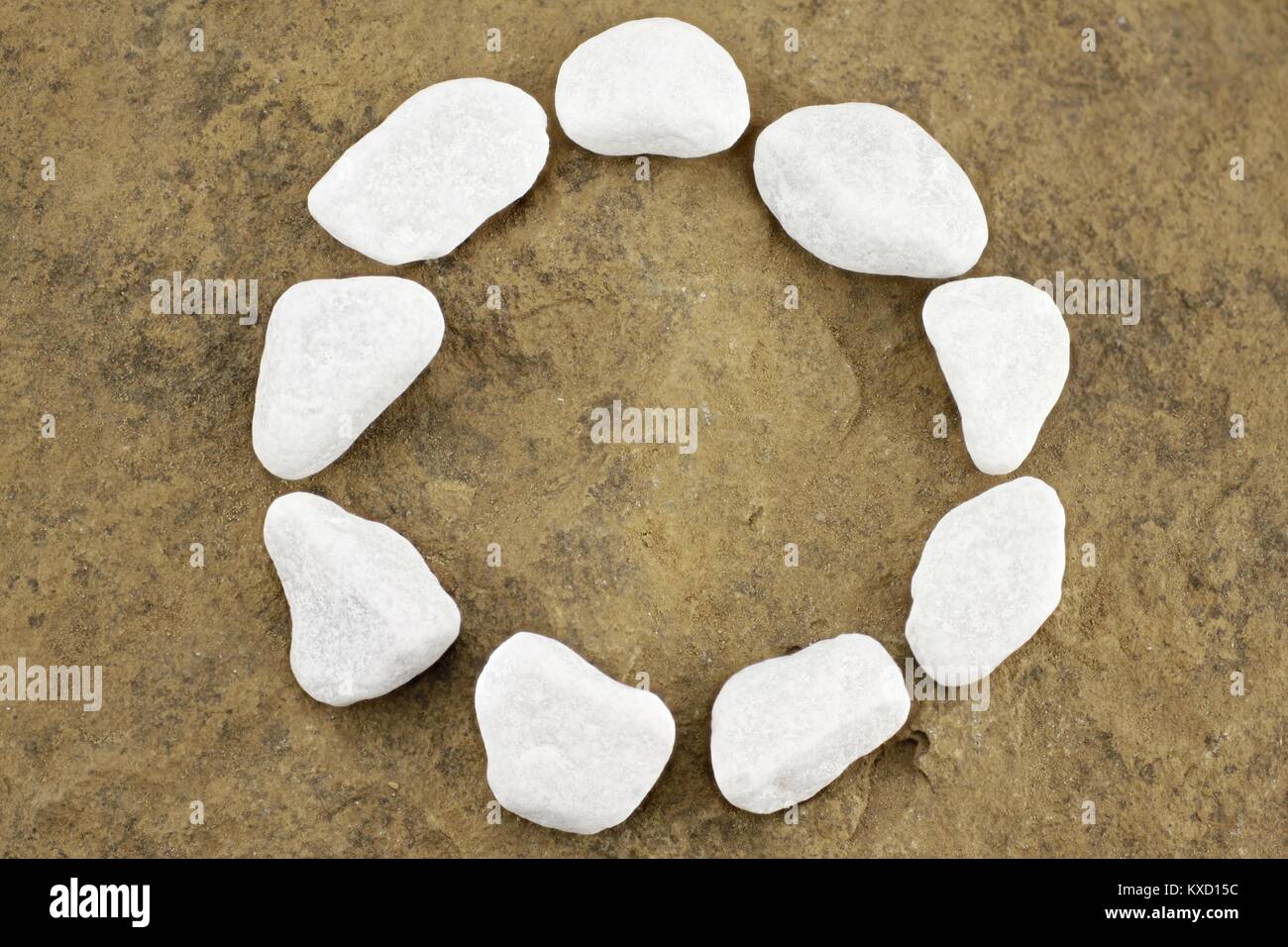 Circle with white pebbles on brown stone chunk Stock Photo