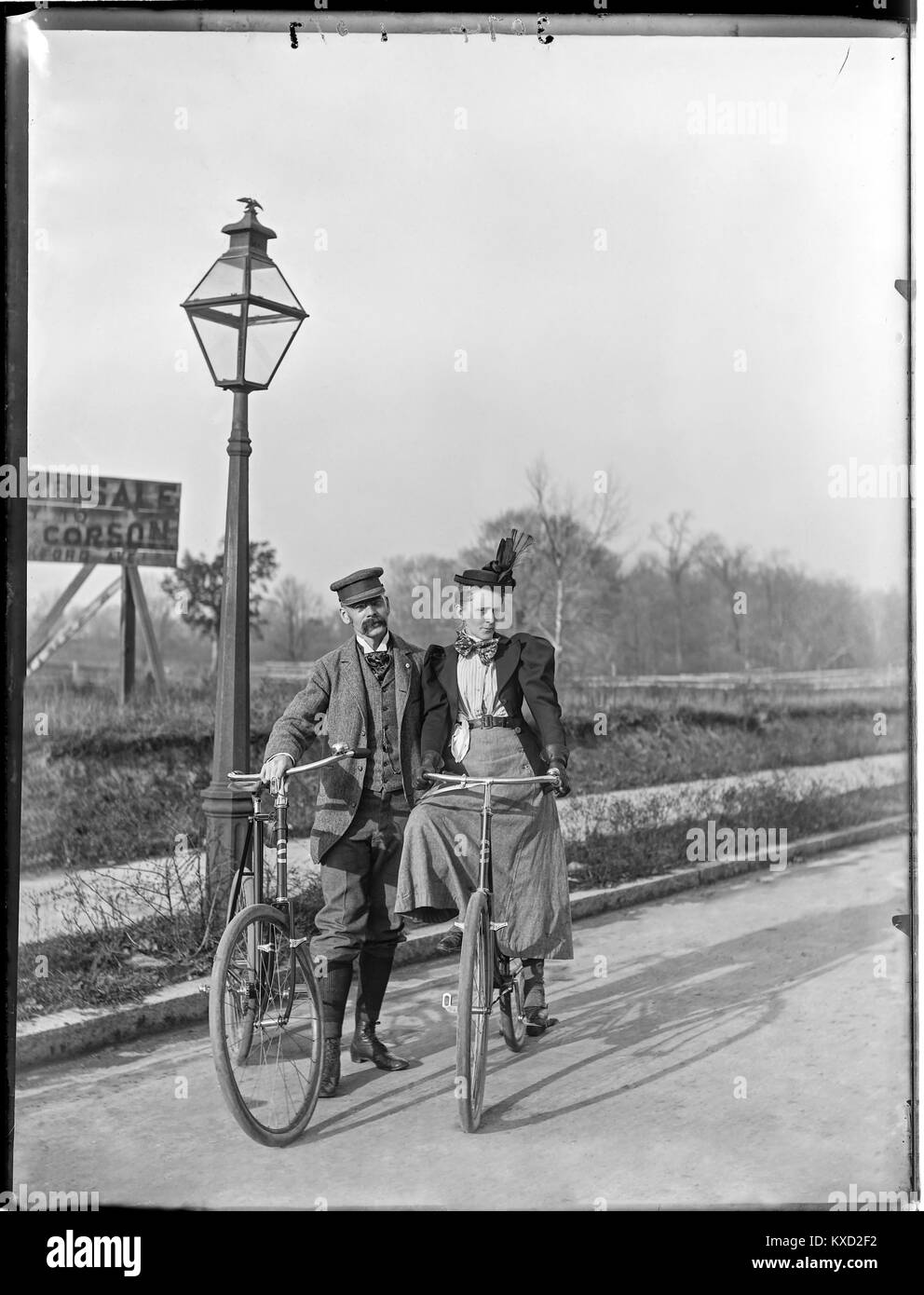 1890 Man & Woman with Bicycles Philadelphia Pennsylvania. Background reads “For Sale Apply to Corson Frankford Ave Phila”. Glass negative plate 6.5' x 8.5'. Stock Photo