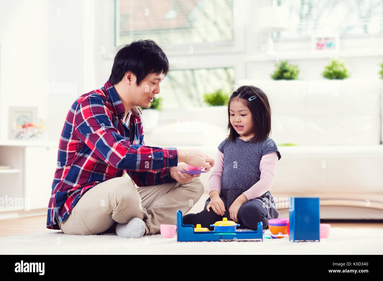 Young happy japanese father playing with his cute little daughter at