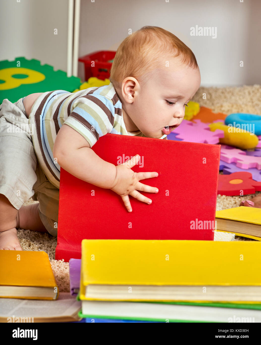 Kid and mother baby boy lying on floor and read book Stock Photo - Alamy