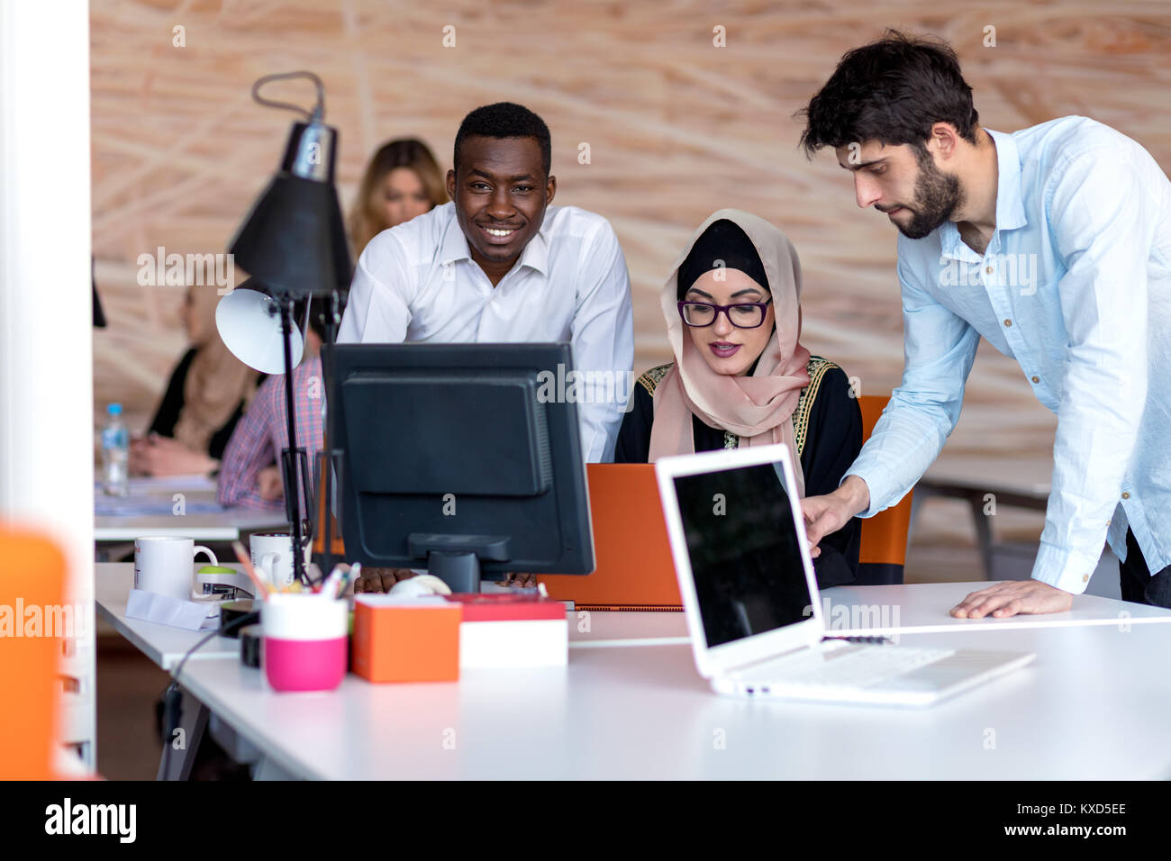 diverse college students using laptop and talking, learning exchanging ideas Stock Photo