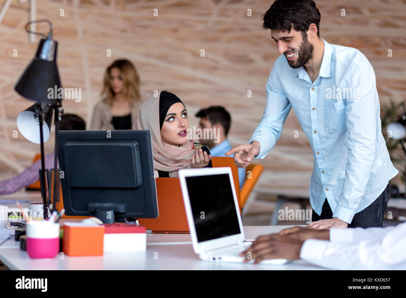 diverse college students using laptop and talking, learning exchanging ideas Stock Photo