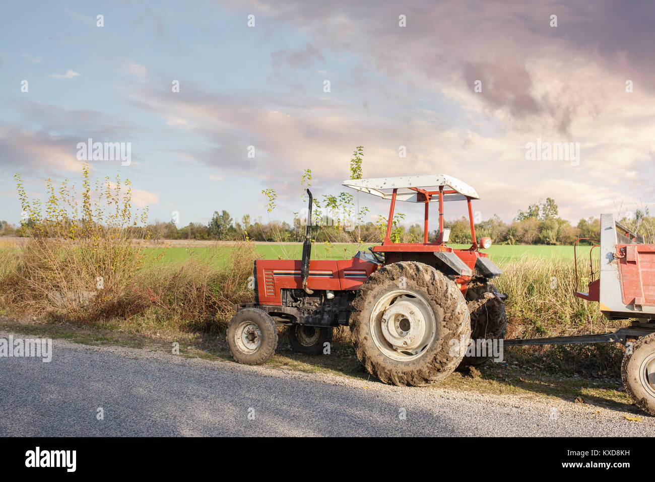 agricultural machinery in the foreground carrying out work in the field Stock Photo