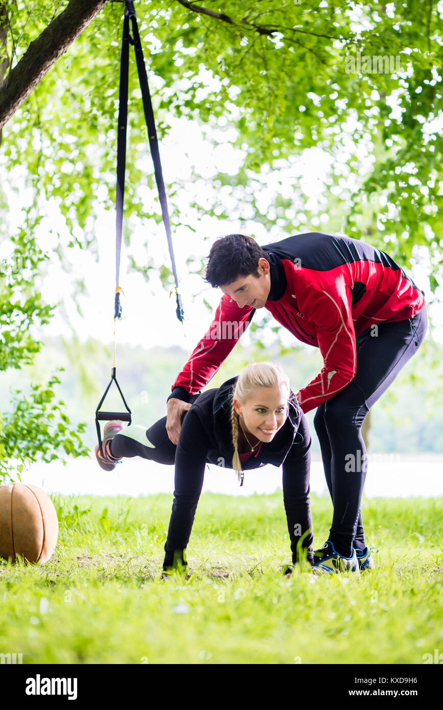 Man and woman at fitness training doing push-ups Stock Photo