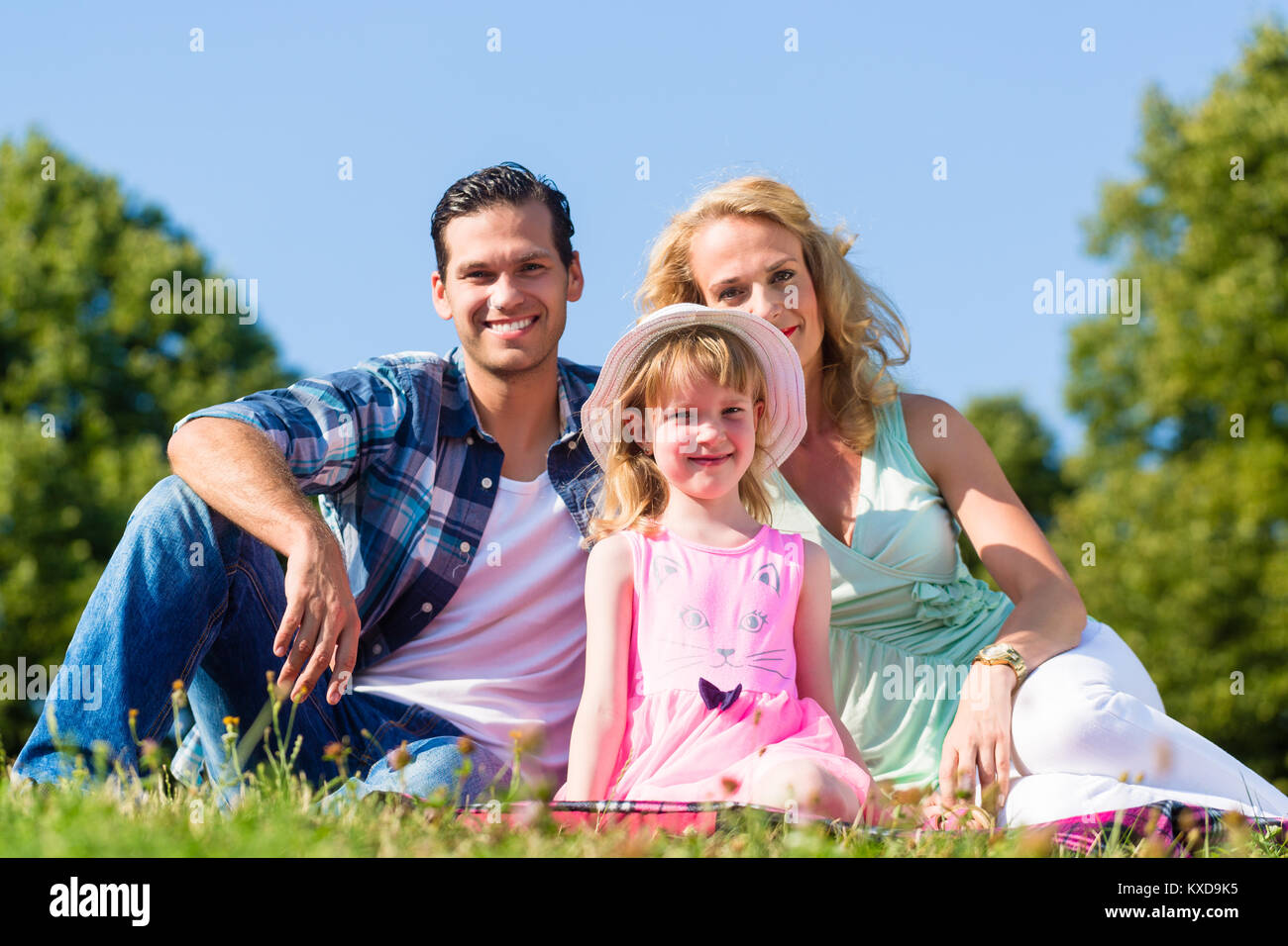 Family photo with father, mother and daughter in meadow Stock Photo