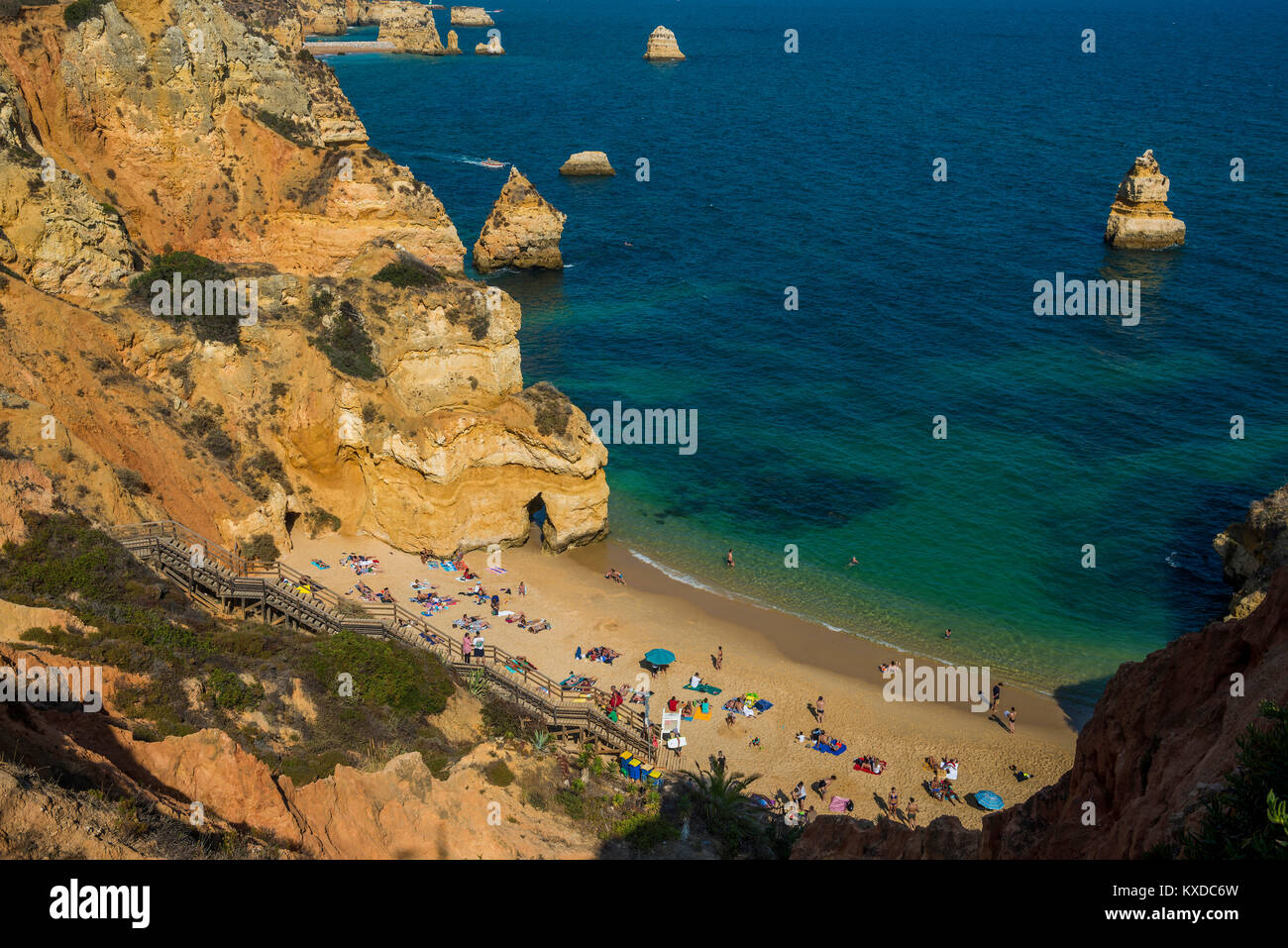 Swimmers on the beach between steep cliffs,Praia do Camilo,Lagos,Algarve,Portugal Stock Photo