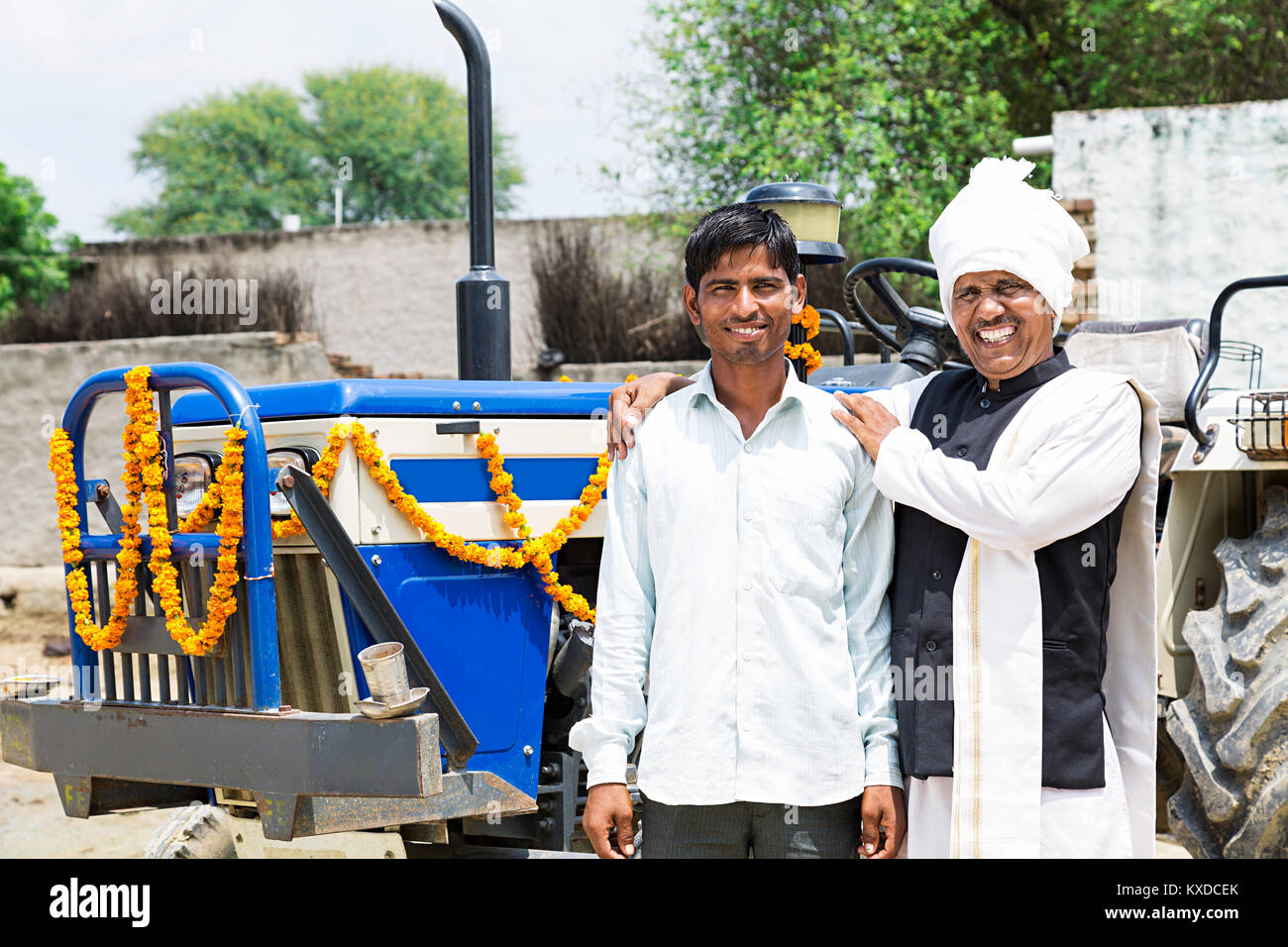2 Indian Farmer Father And Son Standing Near New Tractor Stock Photo