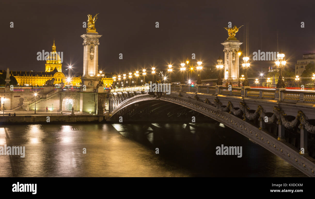 Bridge Pont Alexandre III at night,in the back Hôtel des Invalides with dome Invalidendom,Paris,France Stock Photo