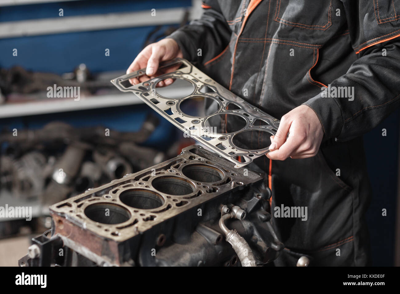 Sealing gasket in hand. The mechanic disassemble block engine vehicle