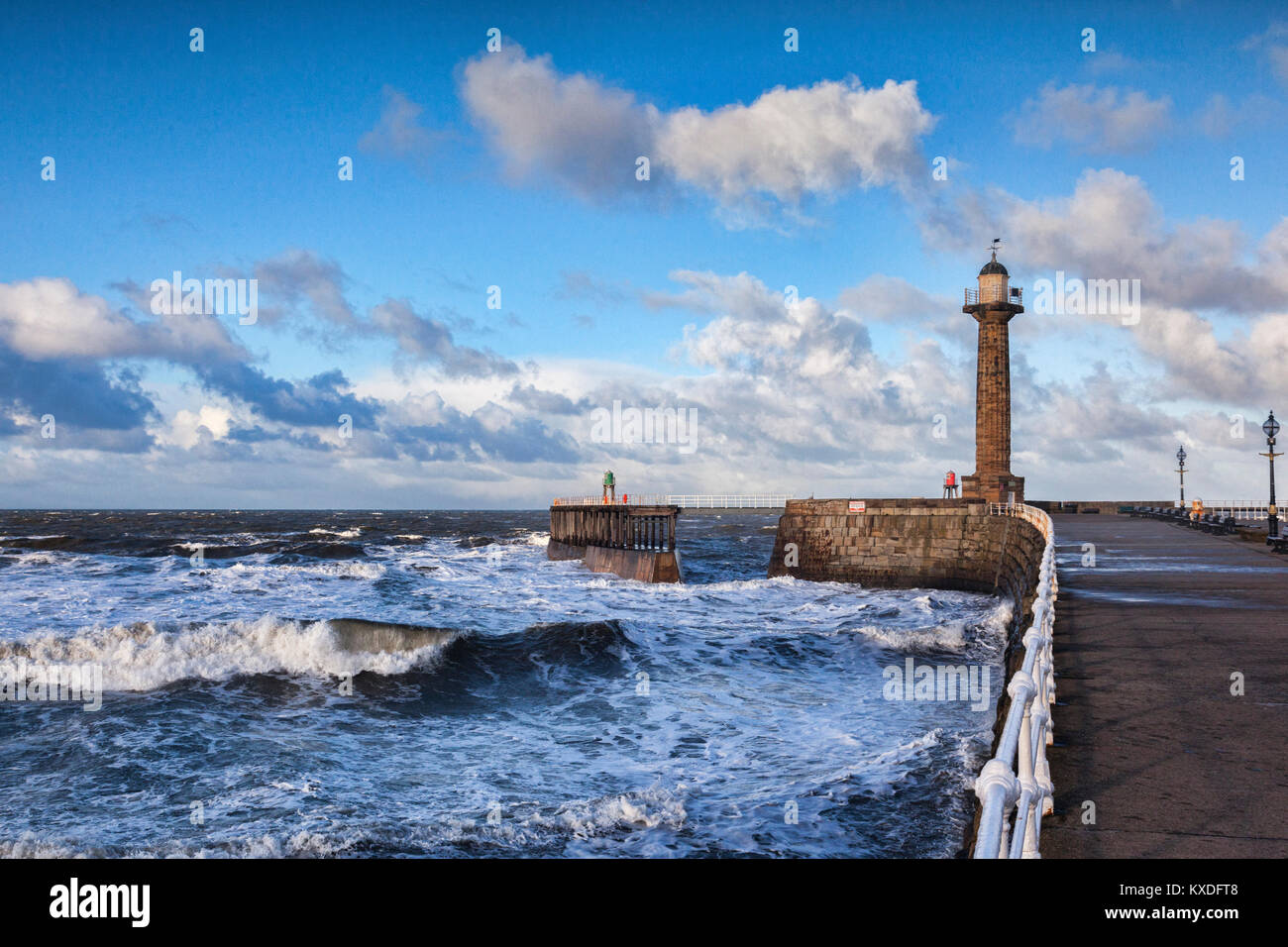 Wind and a rising tide produce rough seas at the entrance to Whitby Harbour in North Yorkshire, on a bright winter afternoon. Stock Photo