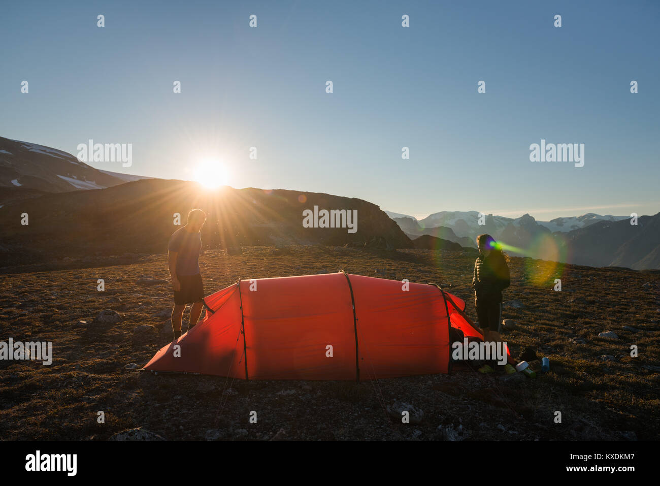 Two persons with red tent, mountain scenery, evening light, Greenland Stock Photo