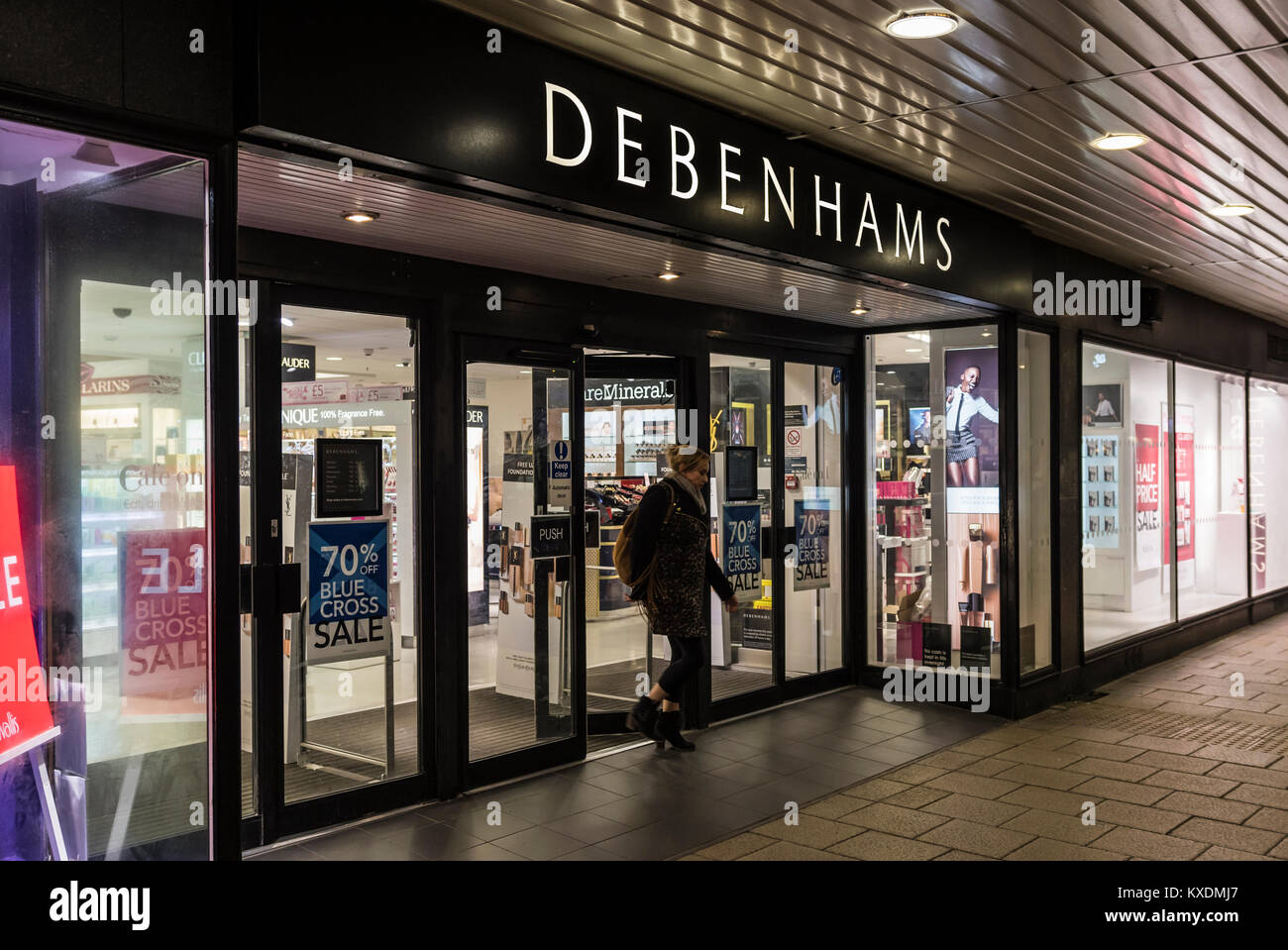 Debenhams shop front entrance open after dark in Worthing, West Sussex, England, UK. Retail store. Stock Photo