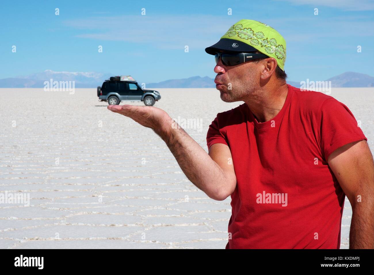 Optical illusion, man holds off-roader on hand, Salar de Uyuni, Uyuni, Potosi, Bolivia Stock Photo